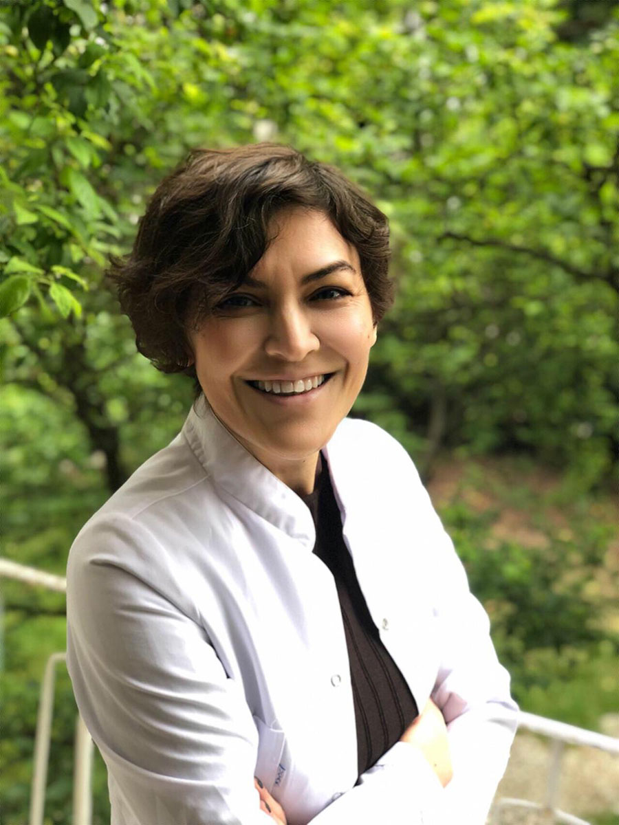 Beyaz önlüklü, gülümseyen Dr. Rezan Cezan portresi